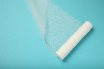 White gauze bandage on blue background. First aid, injury treatment.