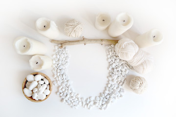 Boho white mockup with candles, cotton yarn and white sea pebble on the desk. Top view flat lay. Space for your text