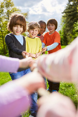 Kinder als multikulturelles Team beim Tauziehen