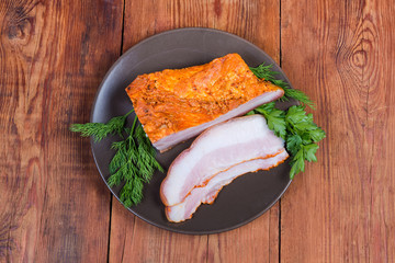 Top view of partly sliced smoked pork belly on dish
