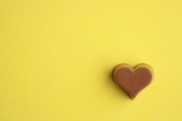 Chocolate bonbon with heart shape in color background