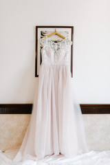 Fototapeta na wymiar White wedding dress hanging in the bedroom. White bride dress