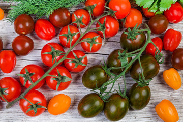 Top view of varicolored cherry tomatoes on old wooden surface