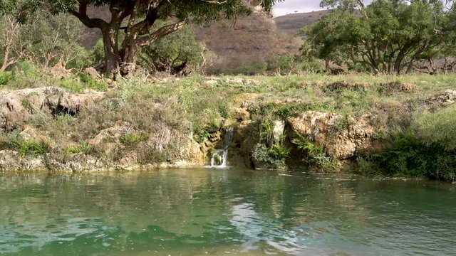 blue water with small waterfall up in the mountains of Salalah, Oman in May.