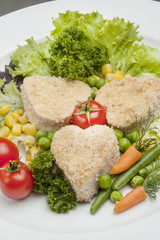 Breaded Chicken Breast. The decor of cherry tomatoes, corn, basil, lettuce. Still life, carrot decorative cut