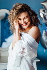Naklejka premium Birthday, blonde woman posing to camera in luxury hotel with balloons behind.. Blue bedroom.