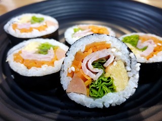 Korean food style, Selective focus of gimbap or kimbap in black plate on dark background, Ready to eat or serve