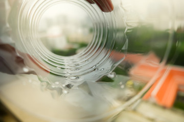 The building through a plastic bottle with a blurred bottle on blurred natrue background. decoration image contain certain grain  noise and soft focus.