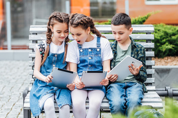 Three  cute children, Two sister and brother, use a laptop to do their schoolwork.