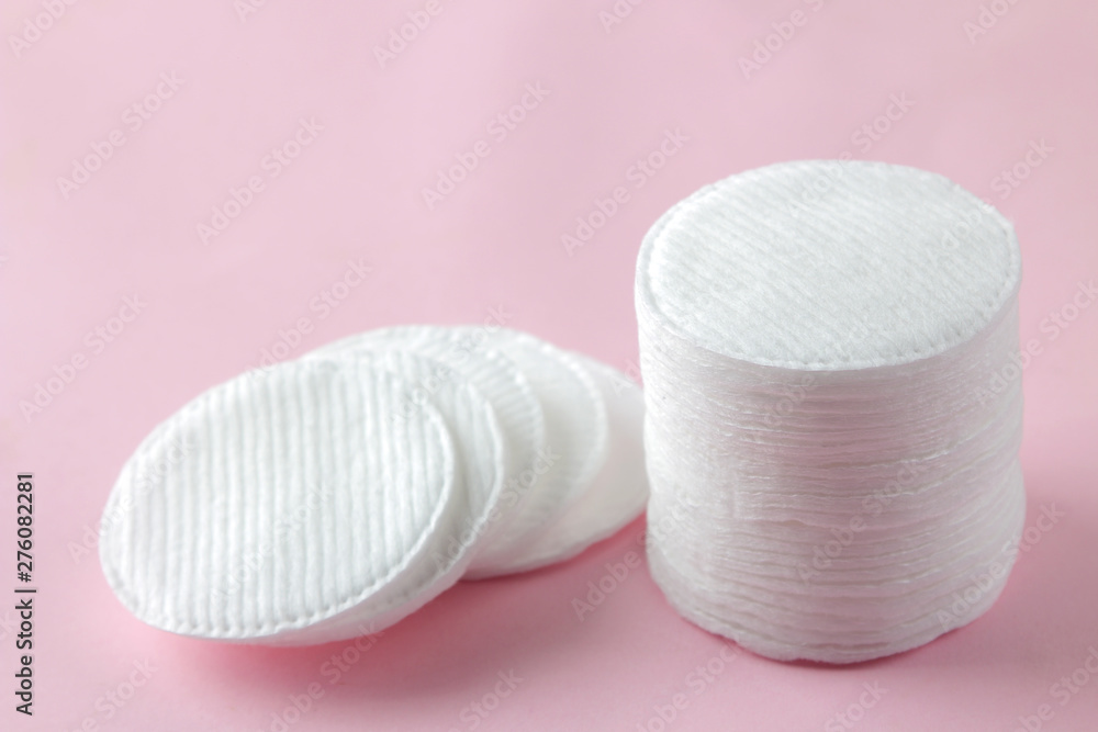 Wall mural Cosmetic cotton pads. A stack of cotton pads on a delicate pink background. spa. close-up.