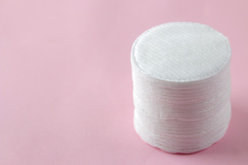 Cosmetic cotton pads. A stack of cotton pads on a delicate pink background. spa. close-up.