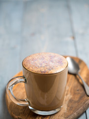 Trendy Coffee with edible glitter. Cup of sparkly coffee or diamond cappuccino on gray table. Copy space for text