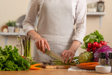 The chef prepares asparagus, with vegetables on a light background. The concept of losing healthy and wholesome food, tasty and healthy food, detox, vegetry