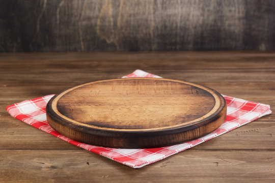 pizza cutting board at rustic wooden table in front