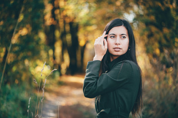 Female beauty portrait surrounded by vivid foliage. Dreamy beautiful girl with long natural black...