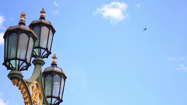 Close-Up Of The Street Lamp And The Helicopter Over The City Of London, England, United Kingdom.