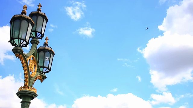 Close-Up Time Lapse Of Street Lamp On Westminster Bridge And The Helicopter Over The London City