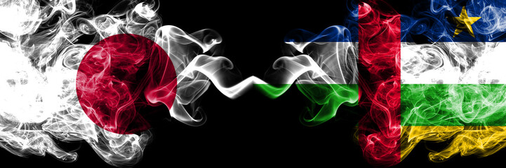 Japan vs Central African Republic smoky mystic flags placed side by side. Thick colored silky smokes combination of Central African Republic and Japanese flag