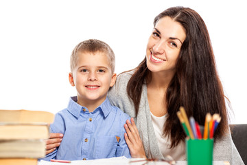 Mom and son are smiling and hugging while doing their homework. Love and tenderness. White background.