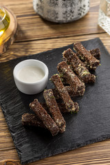 Rye bread croutons with garlic, oil and salt on stone board on wooden table