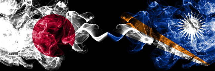 Obraz premium Japan vs Marshall Islands smoky mystic flags placed side by side. Thick colored silky smokes combination of Marshall Islands and Japanese flag