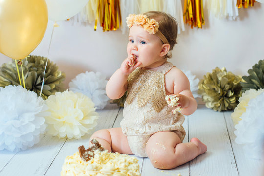 Little baby girl eating cake on her first birthday cakesmash party 