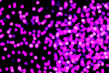 Unfocused abstract purple bokeh on black background. defocused and blurred many round light