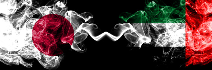 Japan vs United Arab Emirates, Emirati smoky mystic flags placed side by side. Thick colored silky smokes combination of United Arab Emirates, Emirati and Japanese flag