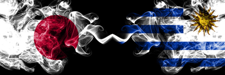 Japan vs Uruguay, Uruguayan smoky mystic flags placed side by side. Thick colored silky smokes combination of Uruguay, Uruguayan and Japanese flag