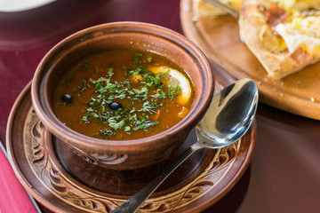 Meat soup from different types of meat and vegetables in a plate.