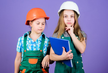 small girls repairing together in workshop. Foreman inspector. Repair. Little kids in helmet with tablet and roller. Labor day. 1 may. engineering idea. house trouble. contractor