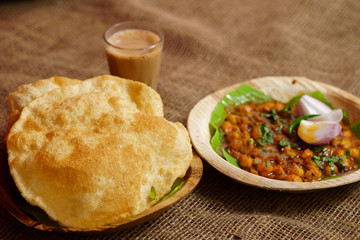 Indian dish spicy Chick Peas curry also known as Chola/Chana Masala or commonly Chole, served served with fried puri or poori