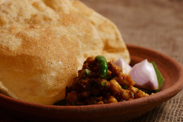 Indian dish spicy Chick Peas curry also known as Chola/Chana Masala or commonly Chole, served served with fried puri or poori