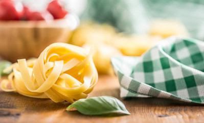 Italian pasta tagliatelle on table with basil and tomatoes