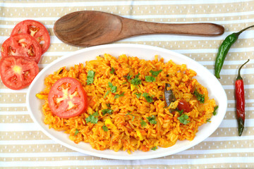 Tomato rice prepared with cooked rice and tomatoes.