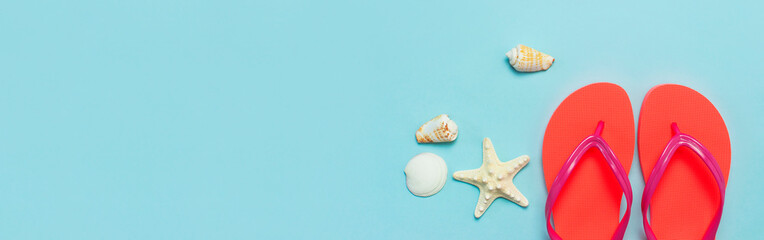 Summer beach sea accessories. Coral flip flops, shells, starfish on blue background top view flat...