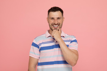 Handsome man over pink background laughing.