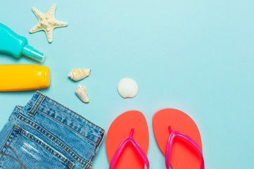 Summer beach sea accessories. Coral flip flops denim shorts shells starfish sunscreen bottle body...
