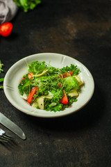 Fototapeta na wymiar salad with tomato, lettuce, arugula and other green leaves. food background. top