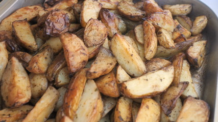 Baked potatoes on the grill. Fatty, unhealthy, high-calorie food for a party or event