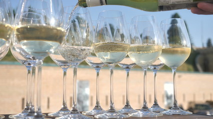 A festive event or wedding, the waiter pours white Italian wine into the bakery.