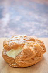 Choux  cream on a wooden tray, the background is a steel table with a rusty pattern.