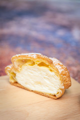 Choux  cream on a wooden tray, the background is a steel table with a rusty pattern.