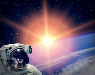 Obraz na płótnie Canvas Astronaut looking at sunrise. The elements of this image furnished by NASA.