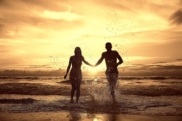 Fototapeta premium silhouette in love sunset sea / newlyweds in honeymoon at sea, vacation luck summer sea beach, silhouette couple at sunset