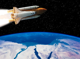Obraz na płótnie Canvas Rocket flying above earth. Stars and outer space. The elements of this image furnished by NASA.