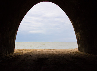 View of the gray-blue sky over the sea from the tunnel.