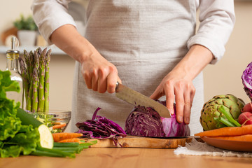 The chef cuts, chops fresh purple lettuce salad. The concept of losing healthy and wholesome food, detox, vegan eating, diet, cooking. Slow food, comfort food, healthy diet, clean eating