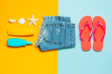 Summer beach sea accessories. Coral flip flops denim shorts shells starfish sunscreen bottle body...