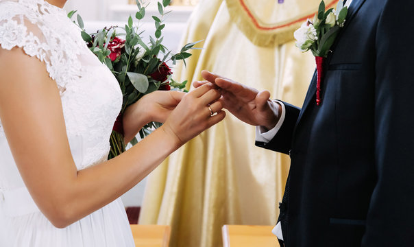 Man and woman exchanging rings at wedding ceremony. Close up image.